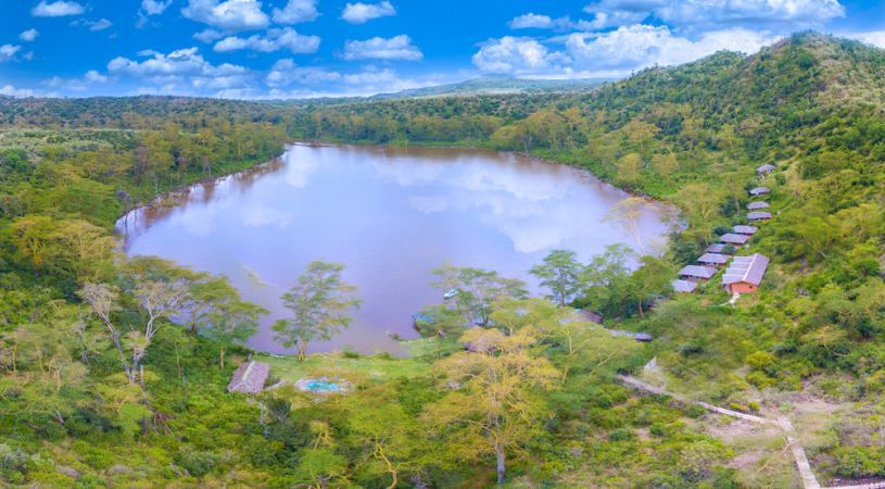 Scenic view of green Crater Lake surrounded by acacia forest