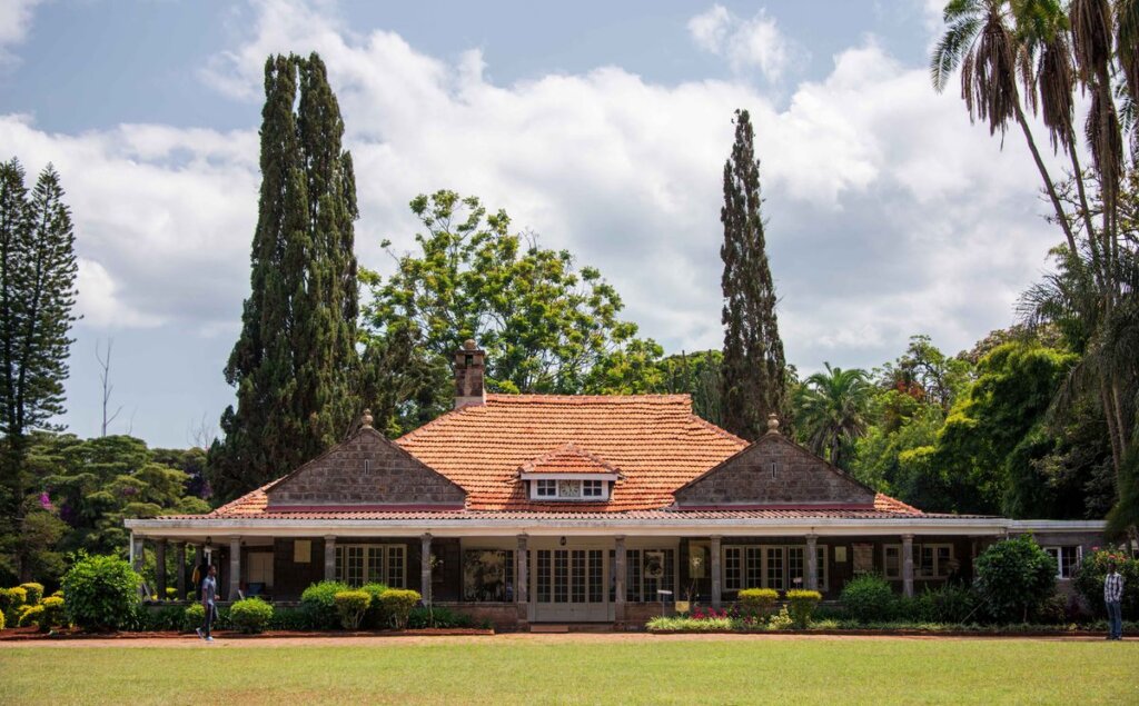 Exterior view of the Karen Blixen Museum, surrounded by gardens and trees