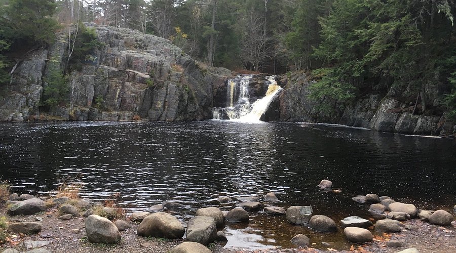 Crystal Falls cascading over rocks surrounded by lush green forest in Central Island National Park