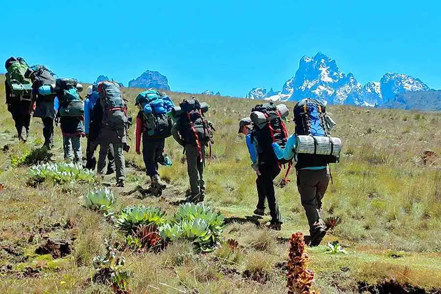 Trekking group navigating rugged mountain terrain with backpacks