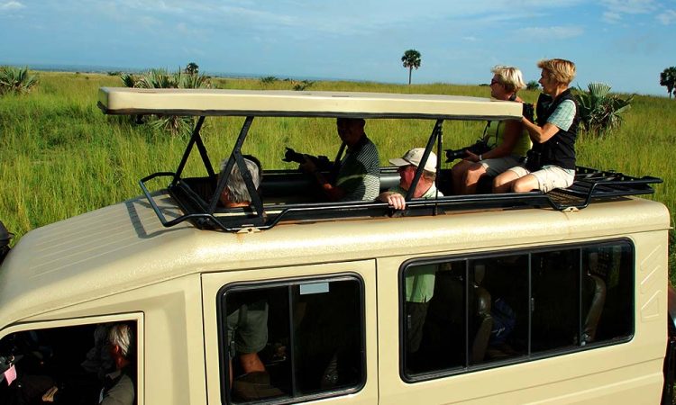 Safari jeep driving through Murchison Falls National Park savannah