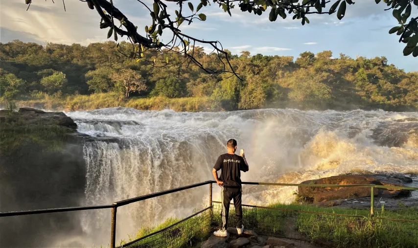 Hiker standing at the top of Murchison Falls with panoramic view of the gorge