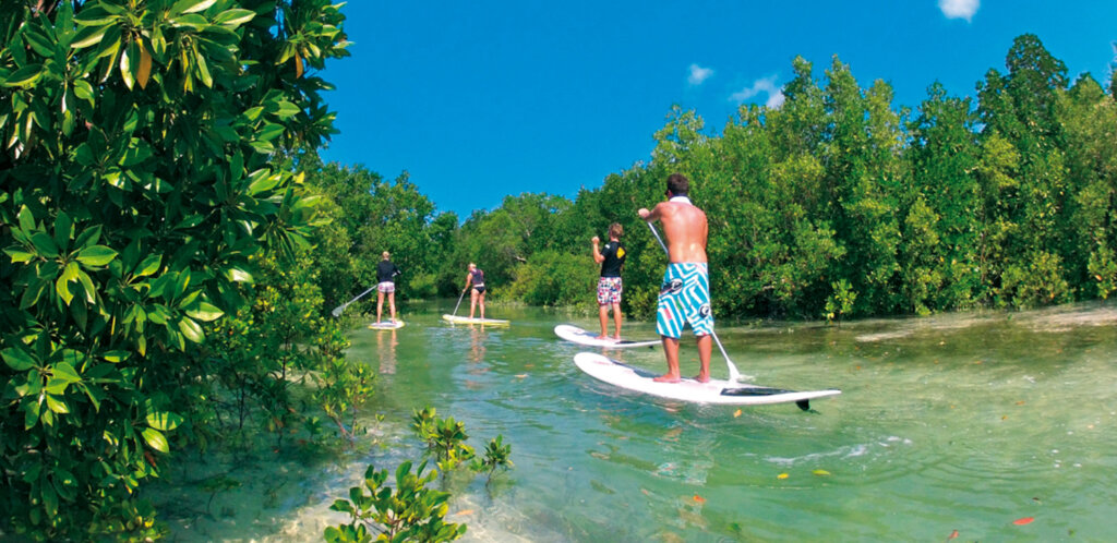 Tourist enjoying stand-up paddle boarding in Zanzibar