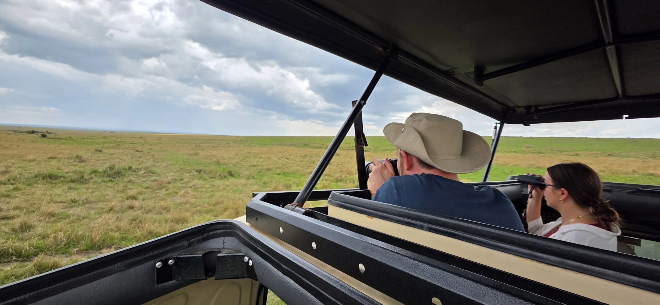 kenya safari - Photographer using a 150-600mm telephoto lens to capture a lion on a Kenyan photographic safari.
