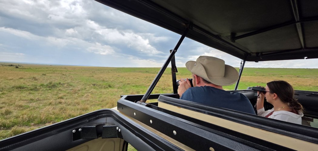 kenya safari - Photographer using a 150-600mm telephoto lens to capture a lion on a Kenyan photographic safari.