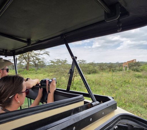 tourist on a Masai Mara safari with cross wild safaris in Kenya photographing Masai Mara